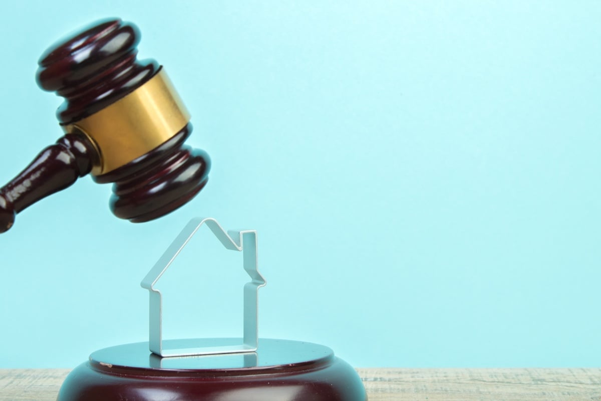 A judge’s gavel over a model house