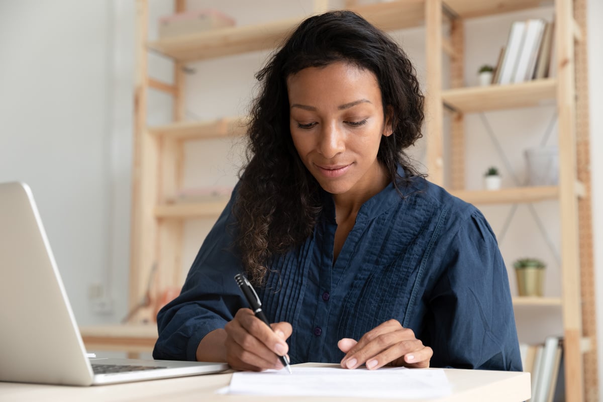 A person sat at a desk looking through documents and conducting a tenant screening process