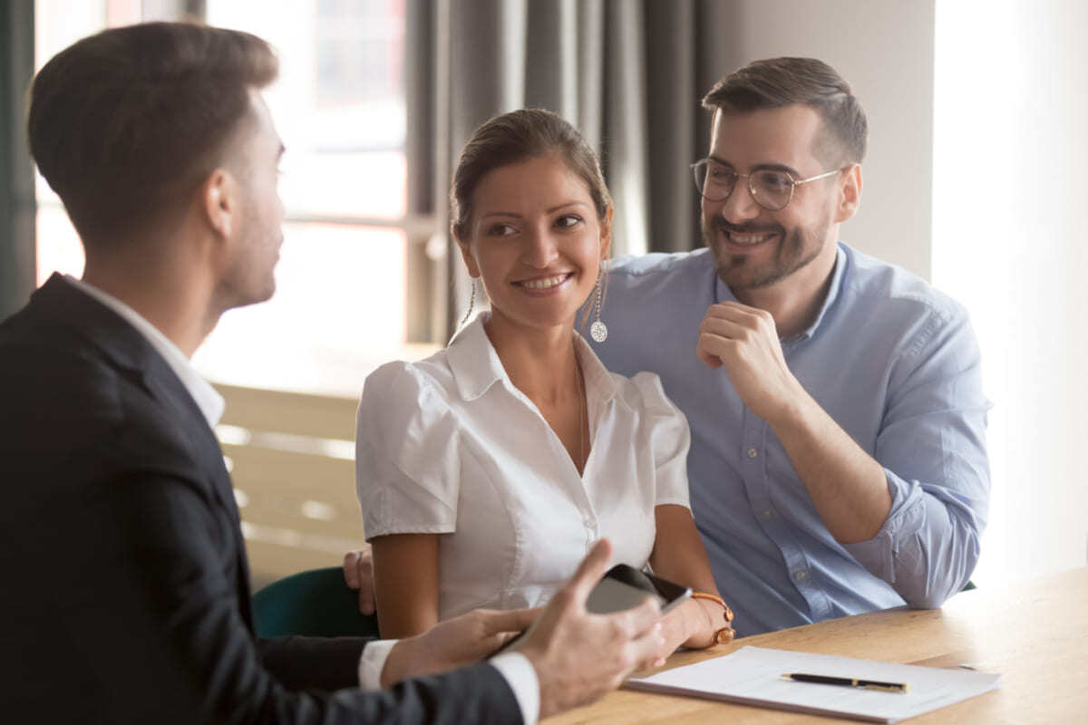 Happy young couple listening to expert property management advice