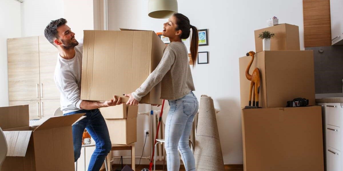 People moving into a property holding boxes