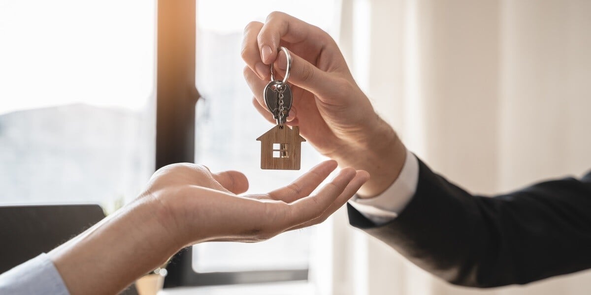 Someone in a suit handing someone keys